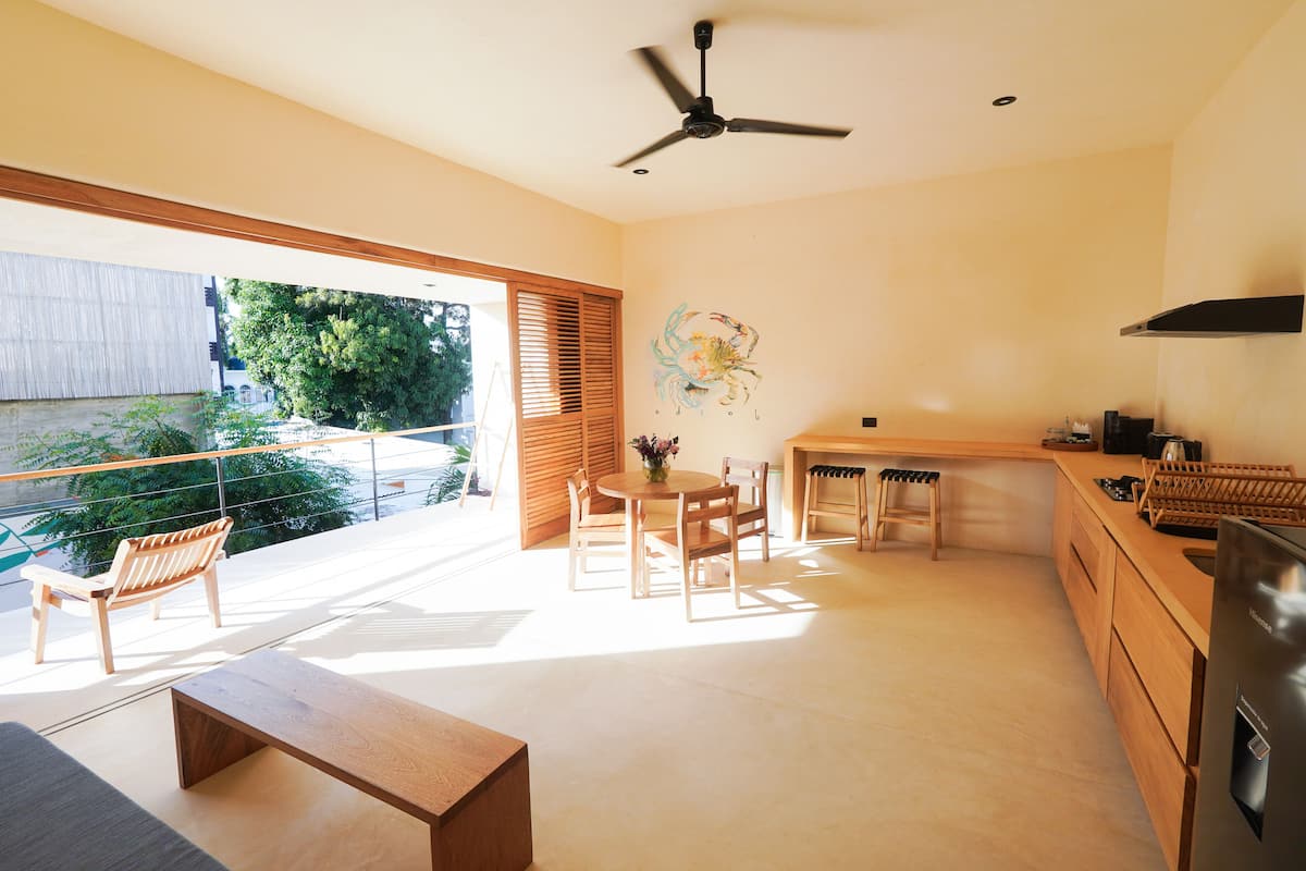 Une cuisine moderne avec un coin repas, des meubles en bois et un ventilateur de plafond.