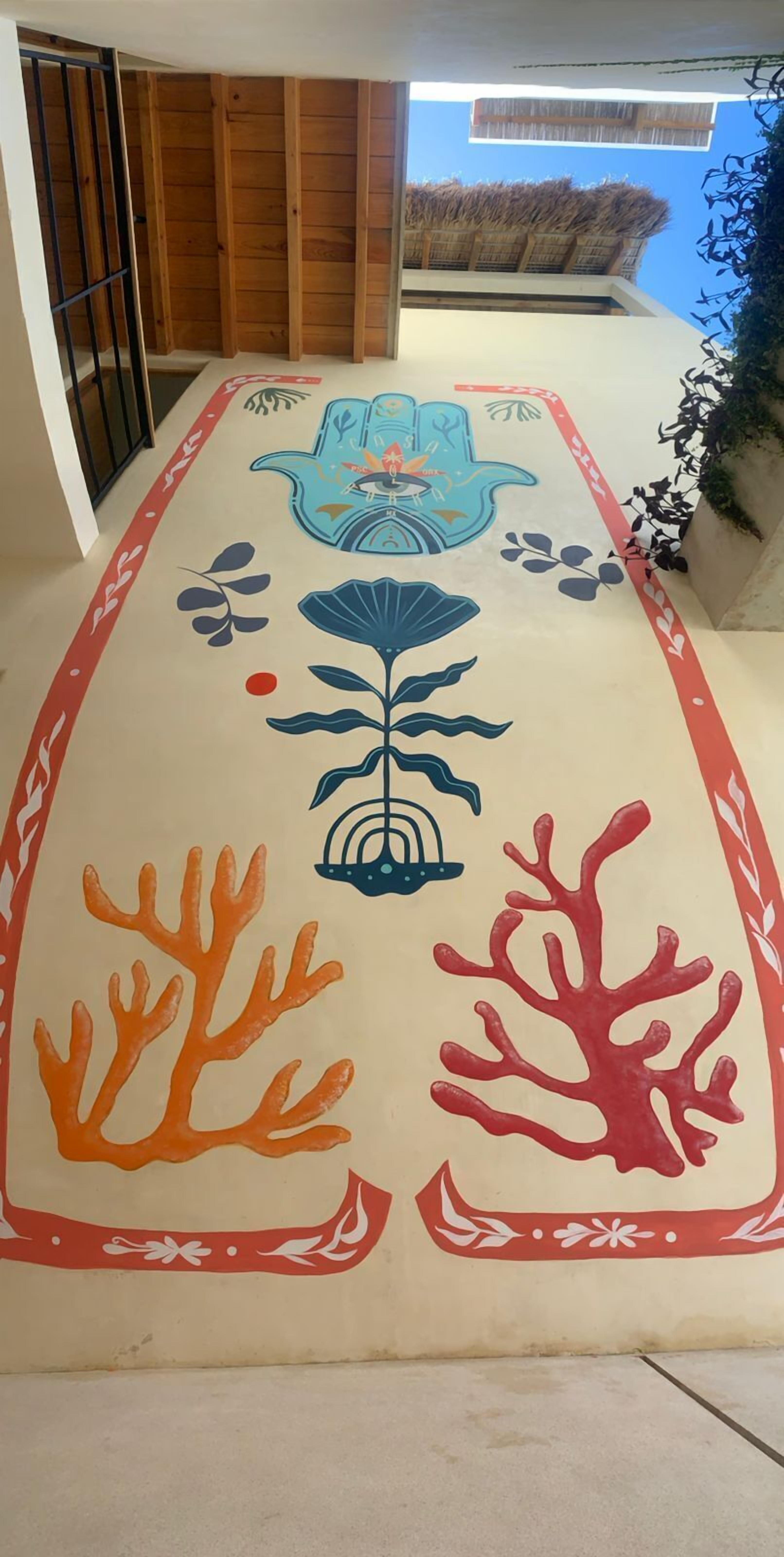 A hallway with a colorful mural featuring a blue fish, a red coral, and a plant.