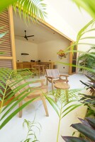 Un interior moderno con muebles de madera, un ventilador de techo y una zona de cocina.
