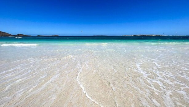 A beach with clear turquoise water and white sand. - La Plage 37 – Sea View, Pool & Steps from the Beach (Orient Bay)