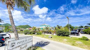 A beachside road with a sign for 'Peter McCoole Irish Pub' and a building in the background.