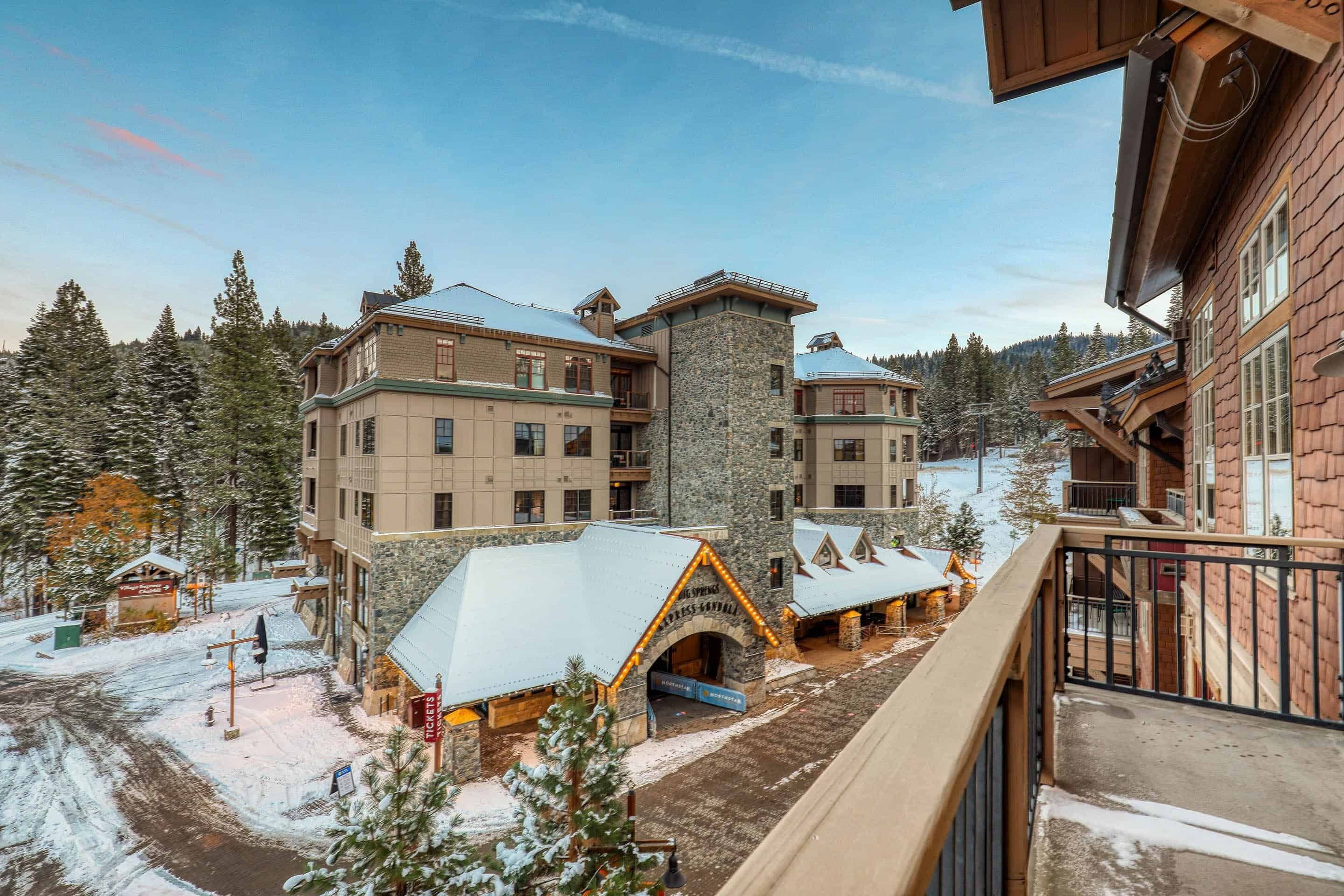 A large lodge with multiple buildings, a stone tower, and a ski lift area.