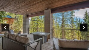 A covered outdoor seating area with a view of a forest. - Ski-in/out Mod/Indust Luxe Schweitzer Mountain (Sandpoint)