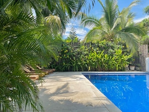 A swimming pool surrounded by lush greenery and a wooden deck. - Villa Tortolas 5 Min Walk To La Ropa Beach (Zihuatanejo)