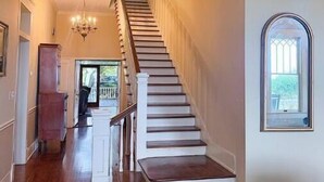 A staircase with a wooden finish, white walls, and a chandelier. - Millarden Farms Main House (Woodbury)