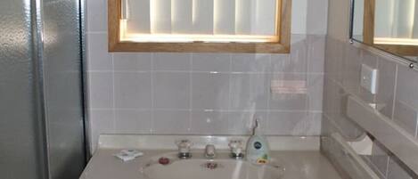 A bathroom with a wooden vanity, a sink, and a mirror.