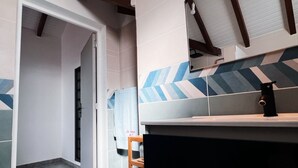 Un baño moderno con un espejo grande, un lavabo y un perchero para toallas.