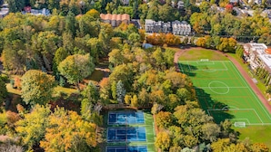 An aerial view of a residential area with a green sports field, surrounded by trees and houses. - Luke's Jedi Meditation Chamber (Seattle)