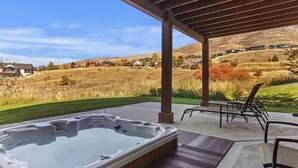 A hot tub under a wooden pergola with a view of a hillside. - Spectacular Mountain Oasis (Eden)