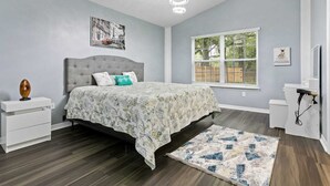 A bedroom with a bed, a nightstand, a dresser, a window, and a ceiling light fixture. - Huge backyard and new reconstruction  (St. Augustine)