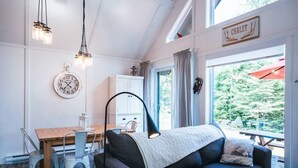 Un salon chaleureux avec un canapé, une table à manger et une horloge au mur.