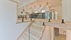 A modern interior with a staircase, a large mirror, and a kitchen area. - Hôtel à la maison - Ô coeur d'Eastman avec spa ! (Eastman)