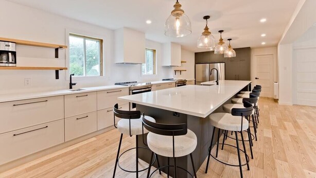 A modern kitchen with a central island, bar stools, pendant lights, and a view of the outdoors. - Hôtel à la maison - Ô coeur d'Eastman avec spa ! (Eastman)