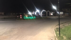 A nighttime view of a building entrance with illuminated arches and a sign reading "Grecnpa k". - Splendid 4-Bedroom with A Pool (Athi River)