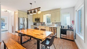 Una cocina moderna con suelo de madera, una isla central y electrodomésticos integrados.