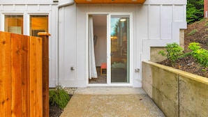 A modern house with a wooden fence, a concrete pathway, and a small garden area. - Skywalker Rebel Base (Seattle)