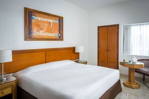 Relax in a serene space with a comfortable bed, a stylish headboard, and a cozy reading nook.