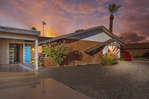 A modern house with a brick exterior, a covered porch, and a gravel driveway. - Old Town Scottsdale Desert Oasis- FREE heated pool (Scottsdale)