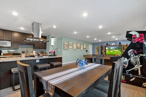 A modern kitchen with dark wooden cabinets, a stainless steel range hood, and a built-in microwave. - Old Town Scottsdale Desert Oasis- FREE heated pool (Scottsdale)