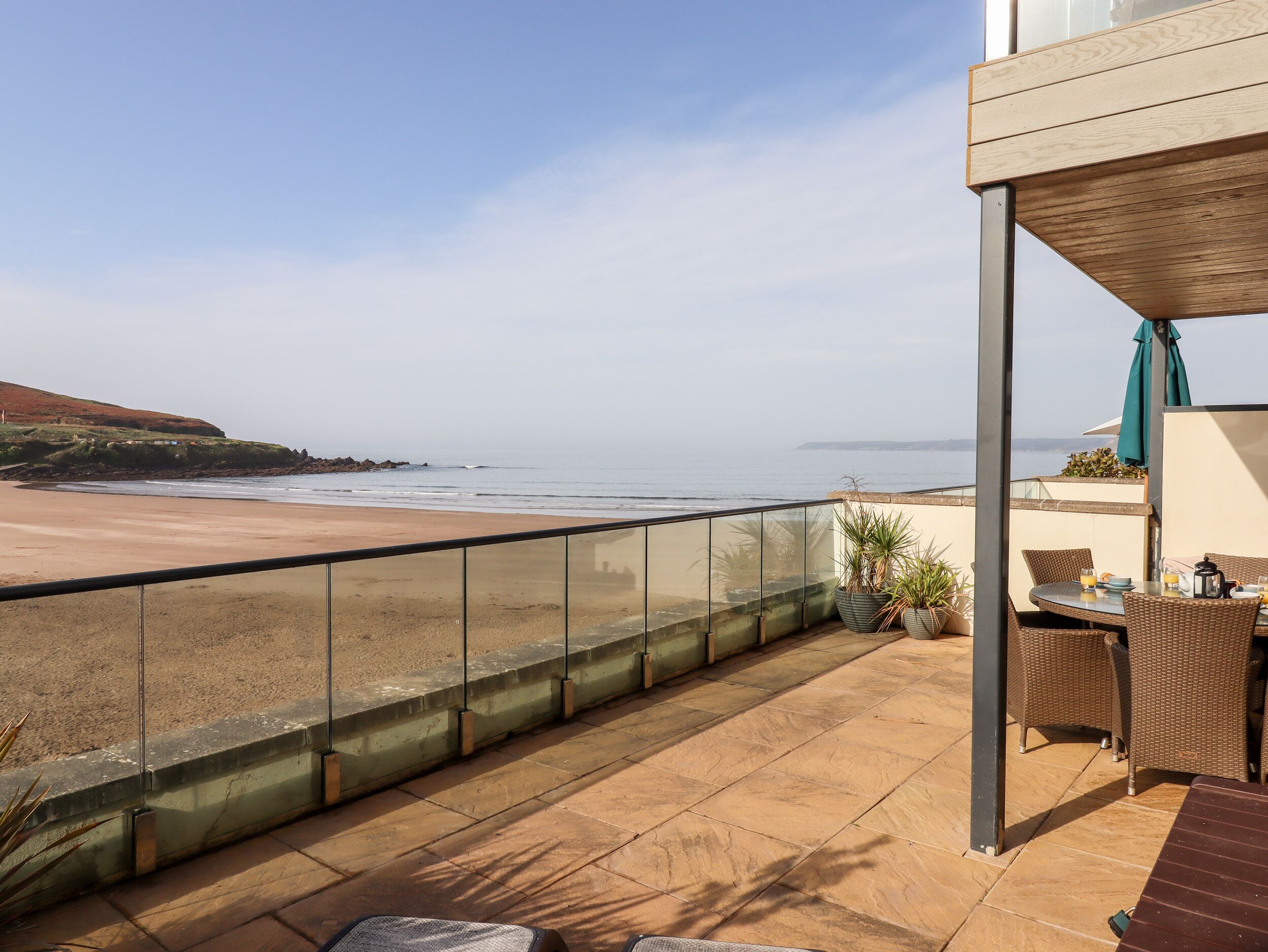 Ein Balkon mit Blick auf Strand und Meer.