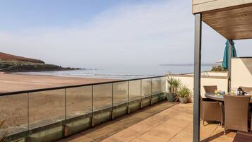 Ein Balkon mit Blick auf Strand und Meer.