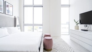 Una camera da letto moderna con un letto grande, una televisione e una finestra vista panoramica.