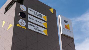 Placa de hotel com diversas comodidades, incluindo restaurante, buffet, bar e lounge, e salão de eventos.