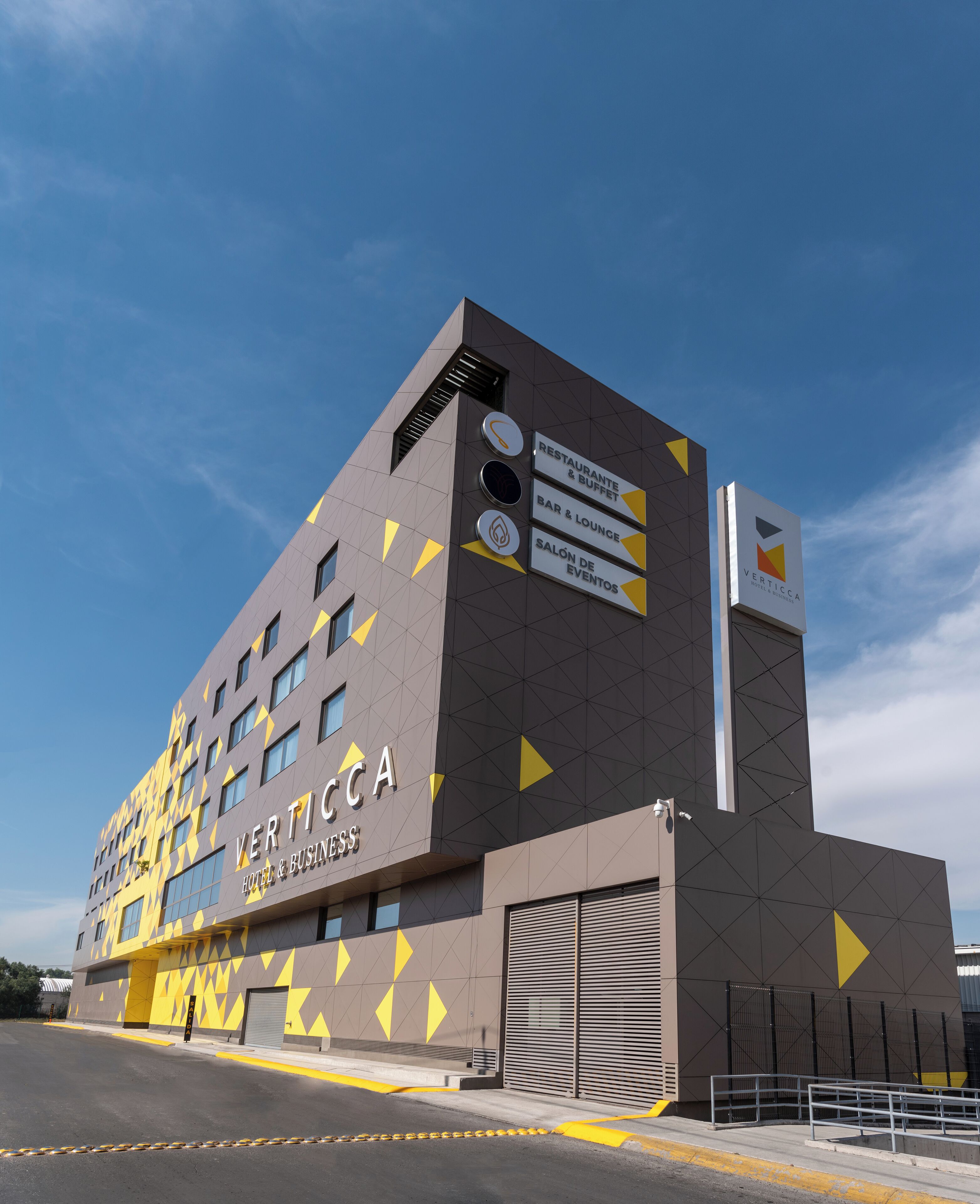 Un edificio moderno con una facciata geometrica, con l'indicazione "Verticca Hotel & Business".