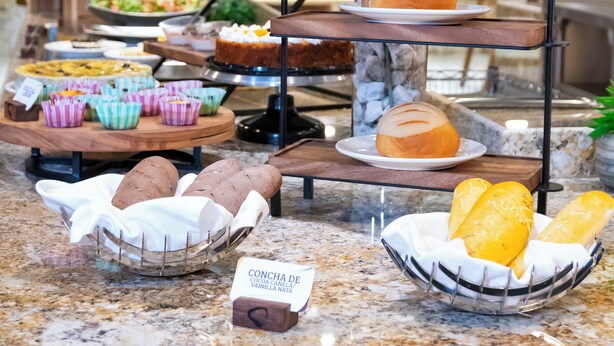Un buffet proposant divers plats et une pancarte indiquant la présence d’un dessert à la vanille.