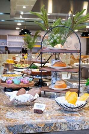 En buffet med forskellige retter og et skilt, der viser en vaniljedessert.