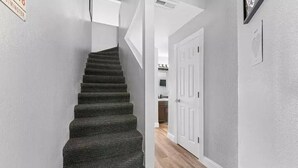 Una escalera con peldaños alfombrados que conduce a una puerta blanca.