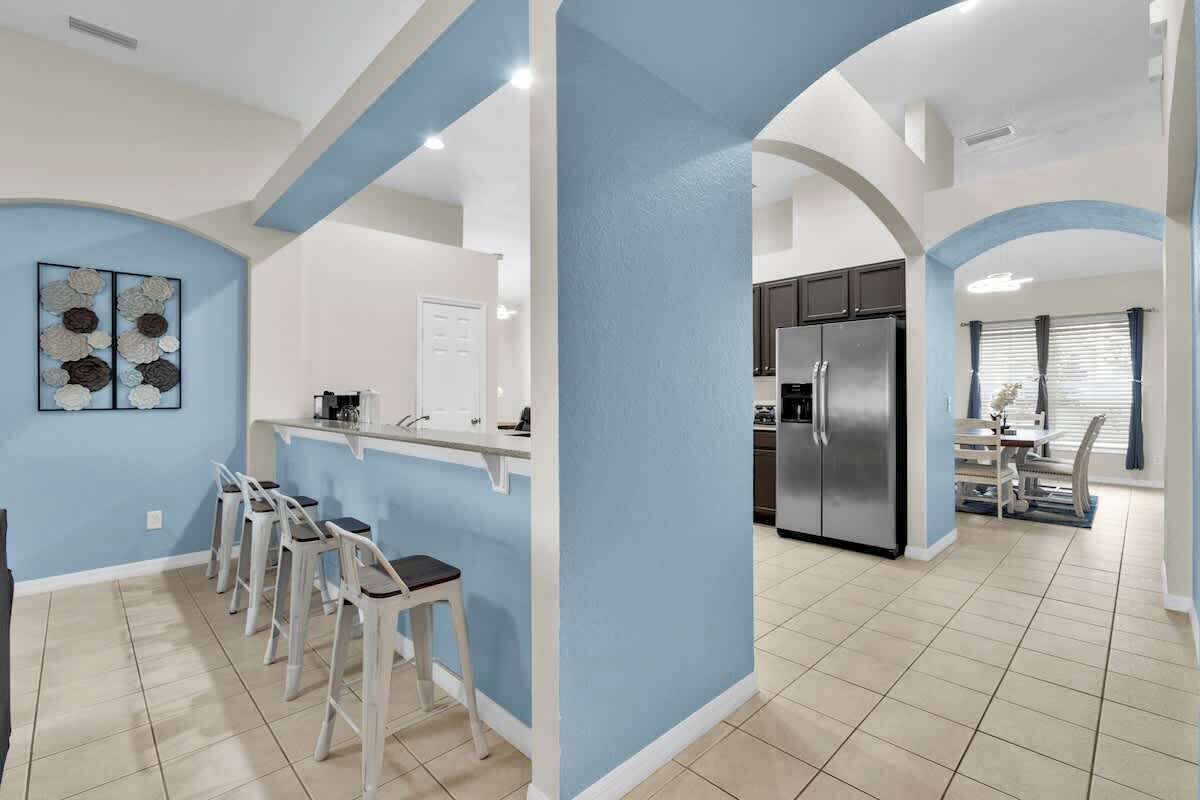 Une cuisine moderne dotée d’un îlot central, de tabourets de bar et d’un coin repas avec une table et des chaises.