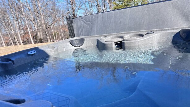 Ein Whirlpool mit mehreren Sitzbereichen und einem Abfluss.
