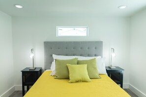 A bedroom with a bed, two nightstands, and a window. - Casa De Poe by Silver Sands Vacation Rentals (Port Aransas)