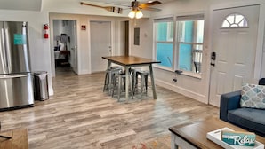 A spacious kitchen with a dining area, a refrigerator, and a ceiling fan.