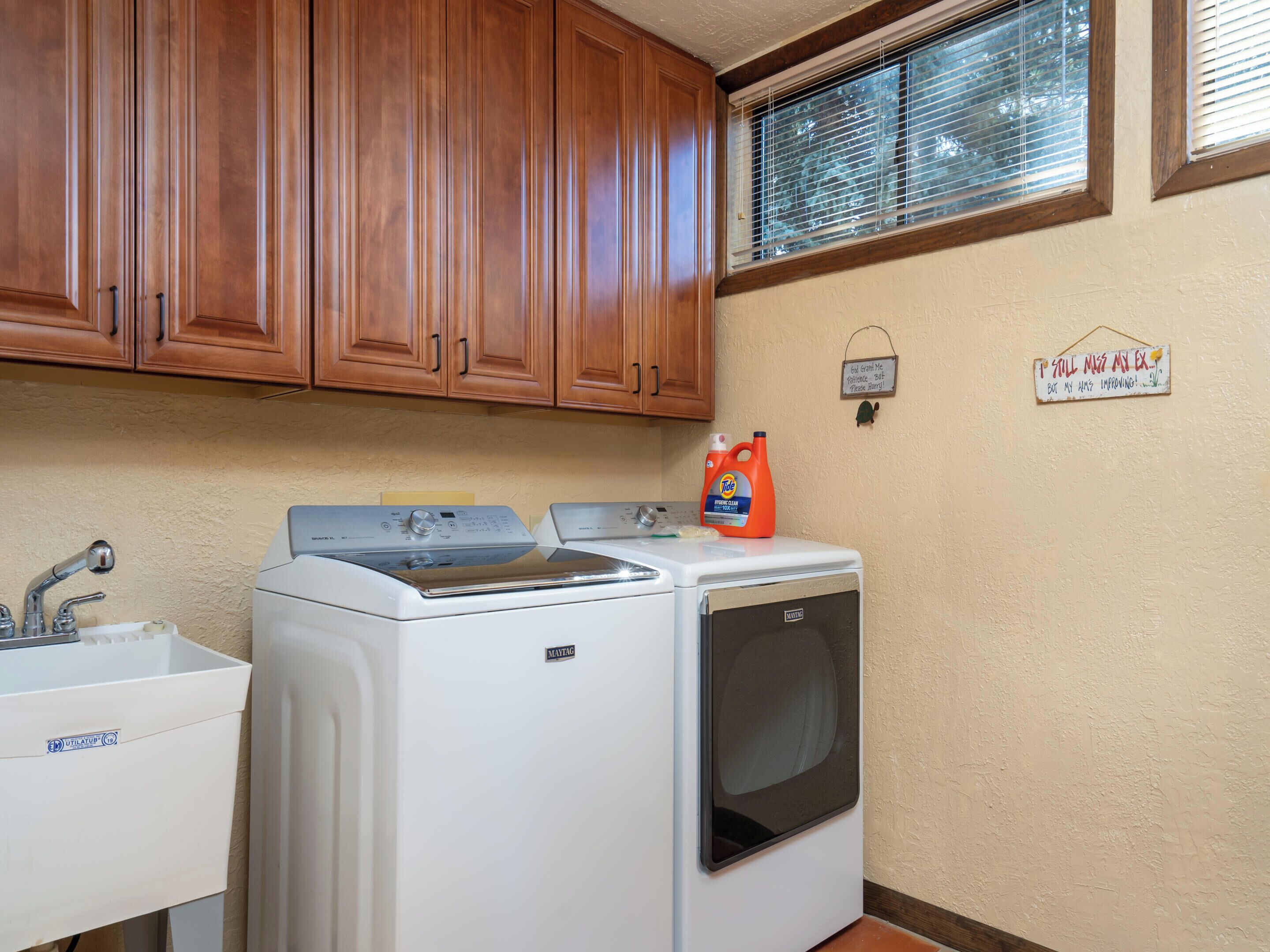 A laundry area with a washing machine, dryer, and a sink.