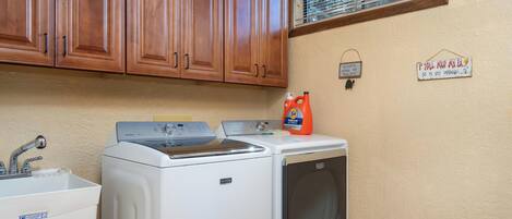 A laundry area with a washing machine, dryer, and a sink.