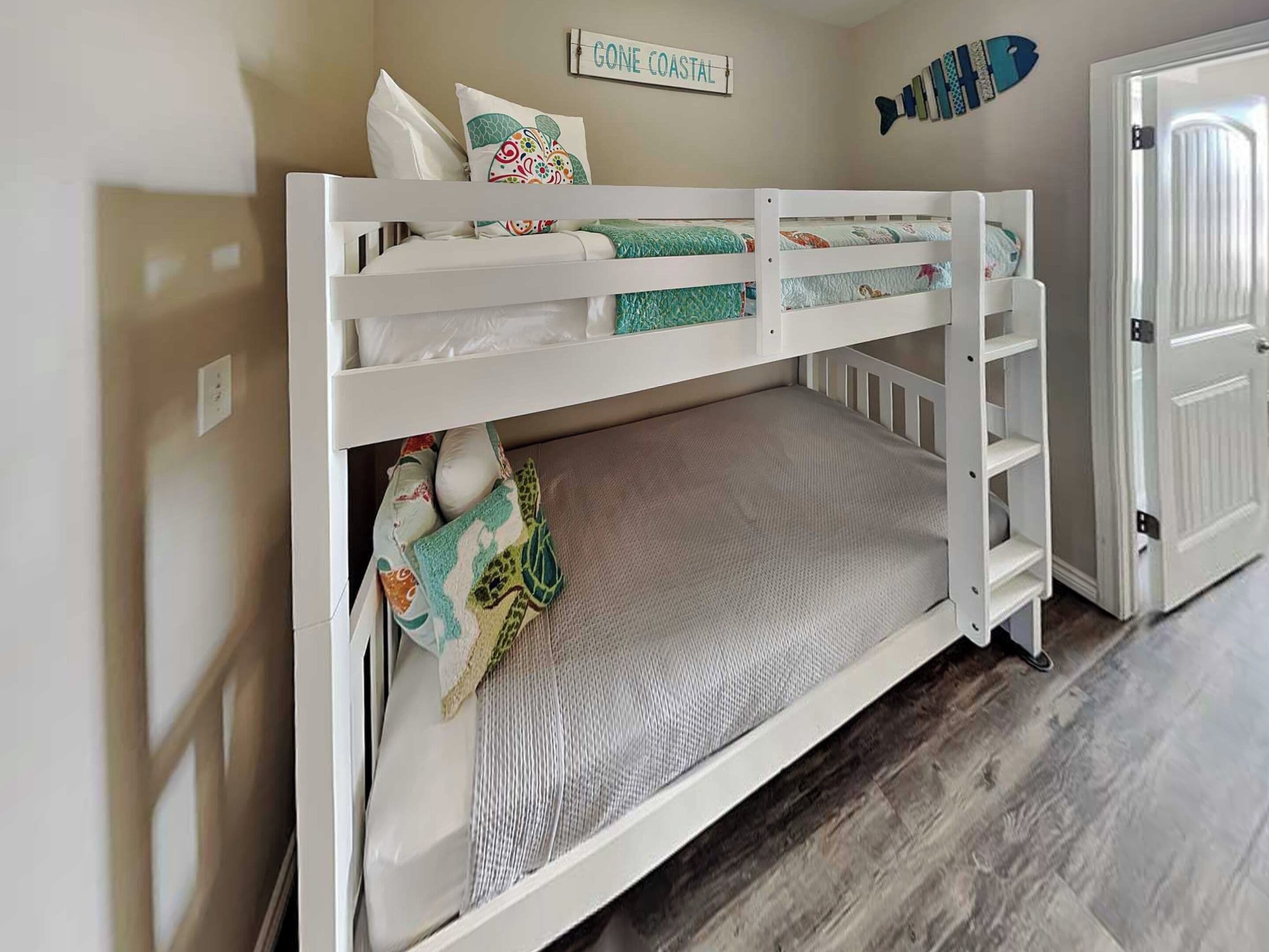 A bunk bed with a mattress, pillows, and a blanket.