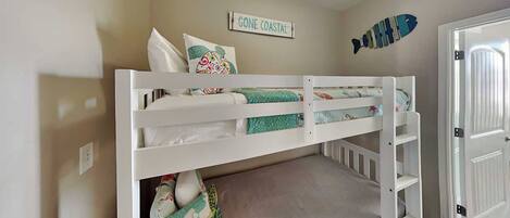 A bunk bed with a mattress, pillows, and a blanket.