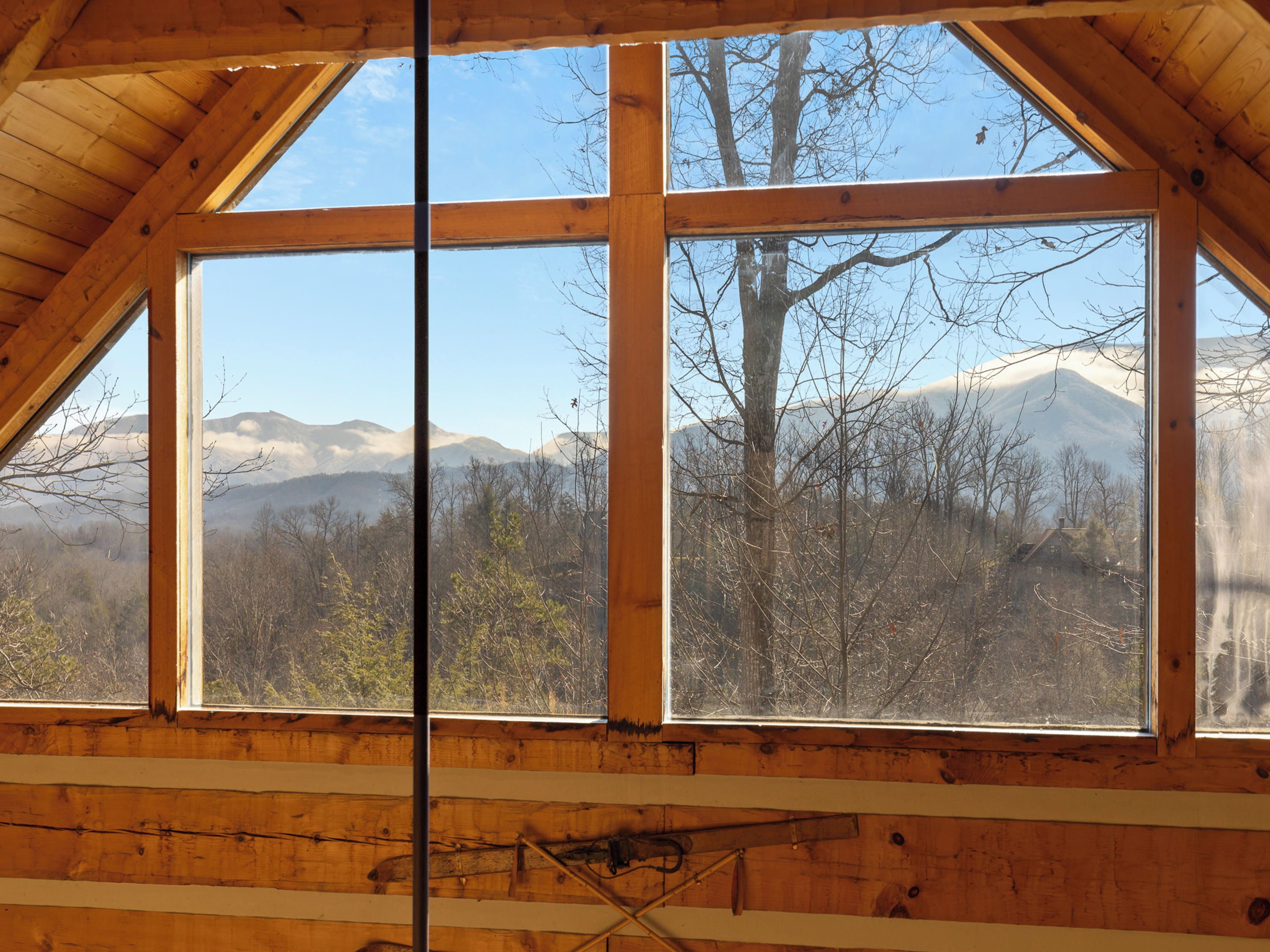A room with a large window offering a view of a mountainous landscape.