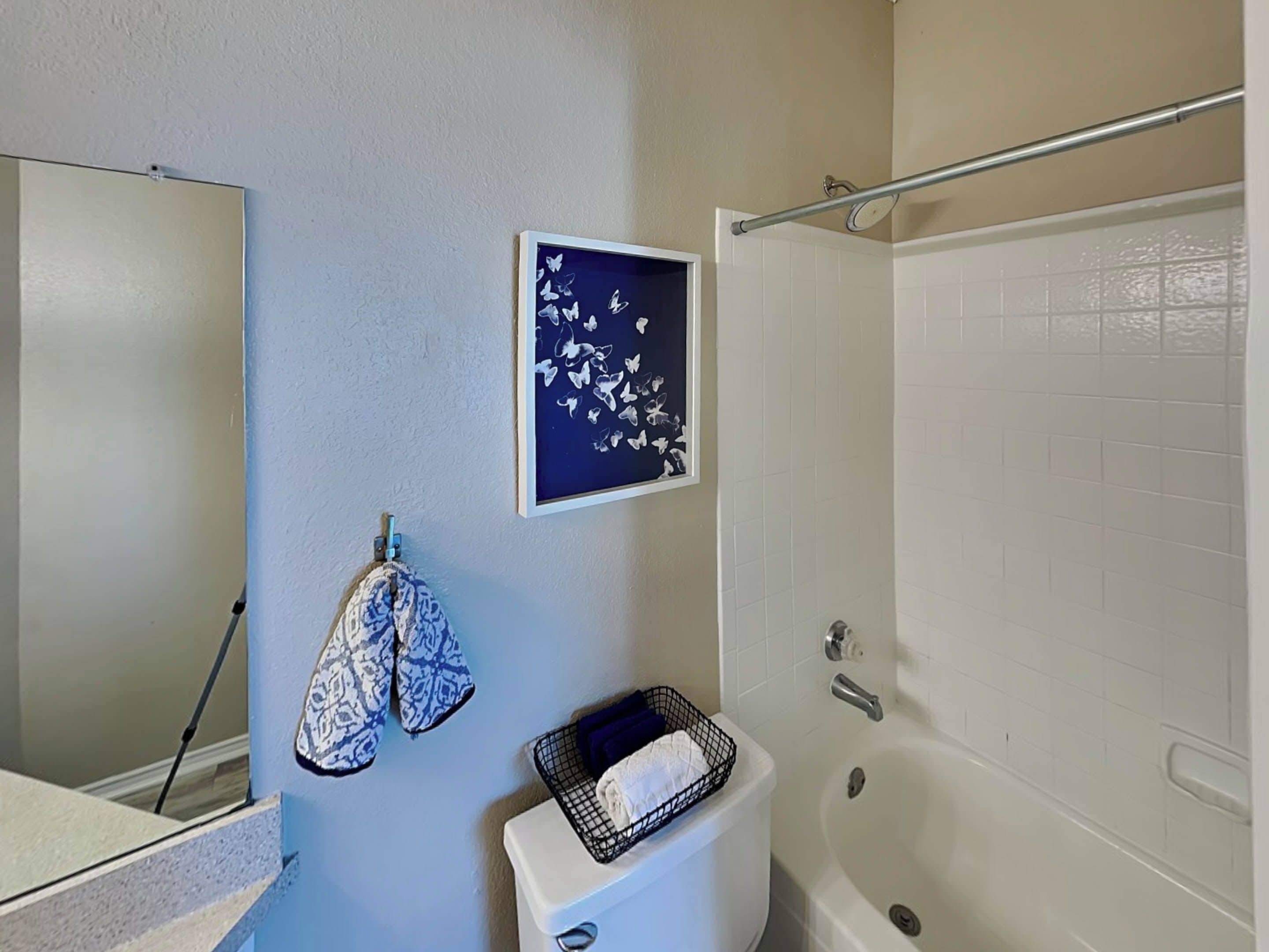 A bathroom with a toilet, a sink, a bathtub, and a towel rack.