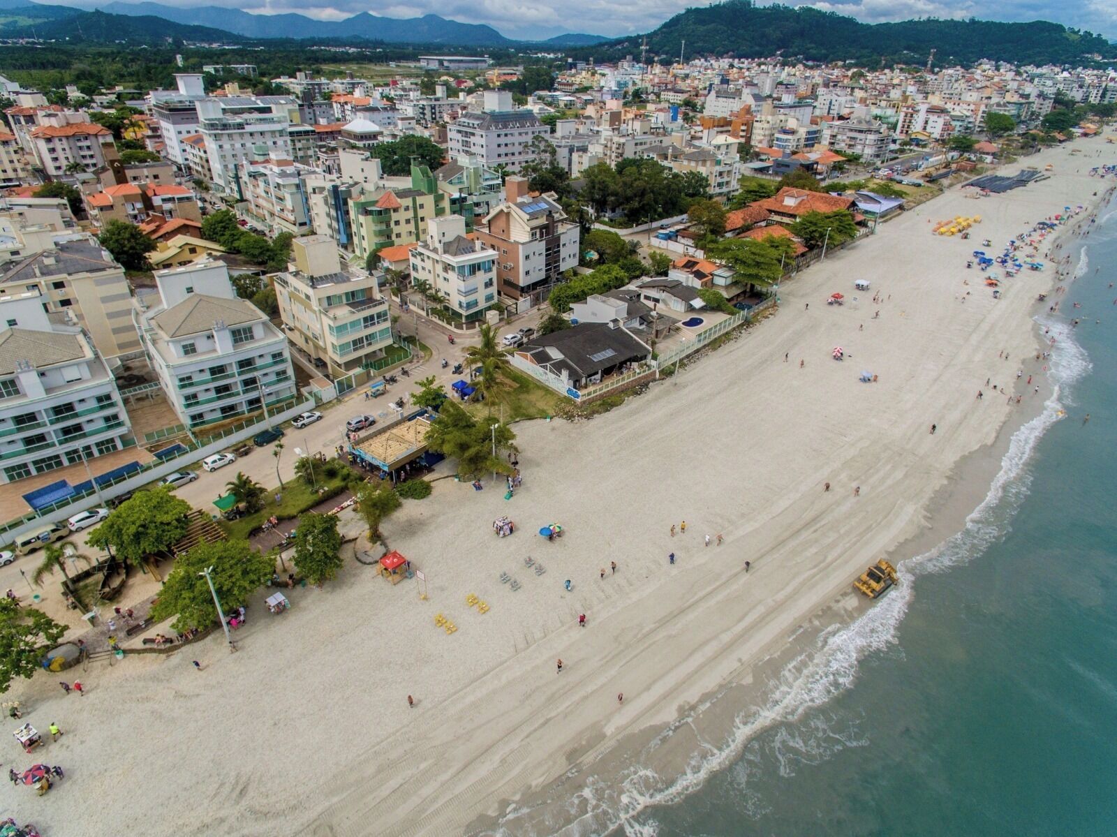 Un paisaje urbano costero con una playa extensa, edificios y una vista despejada del océano.