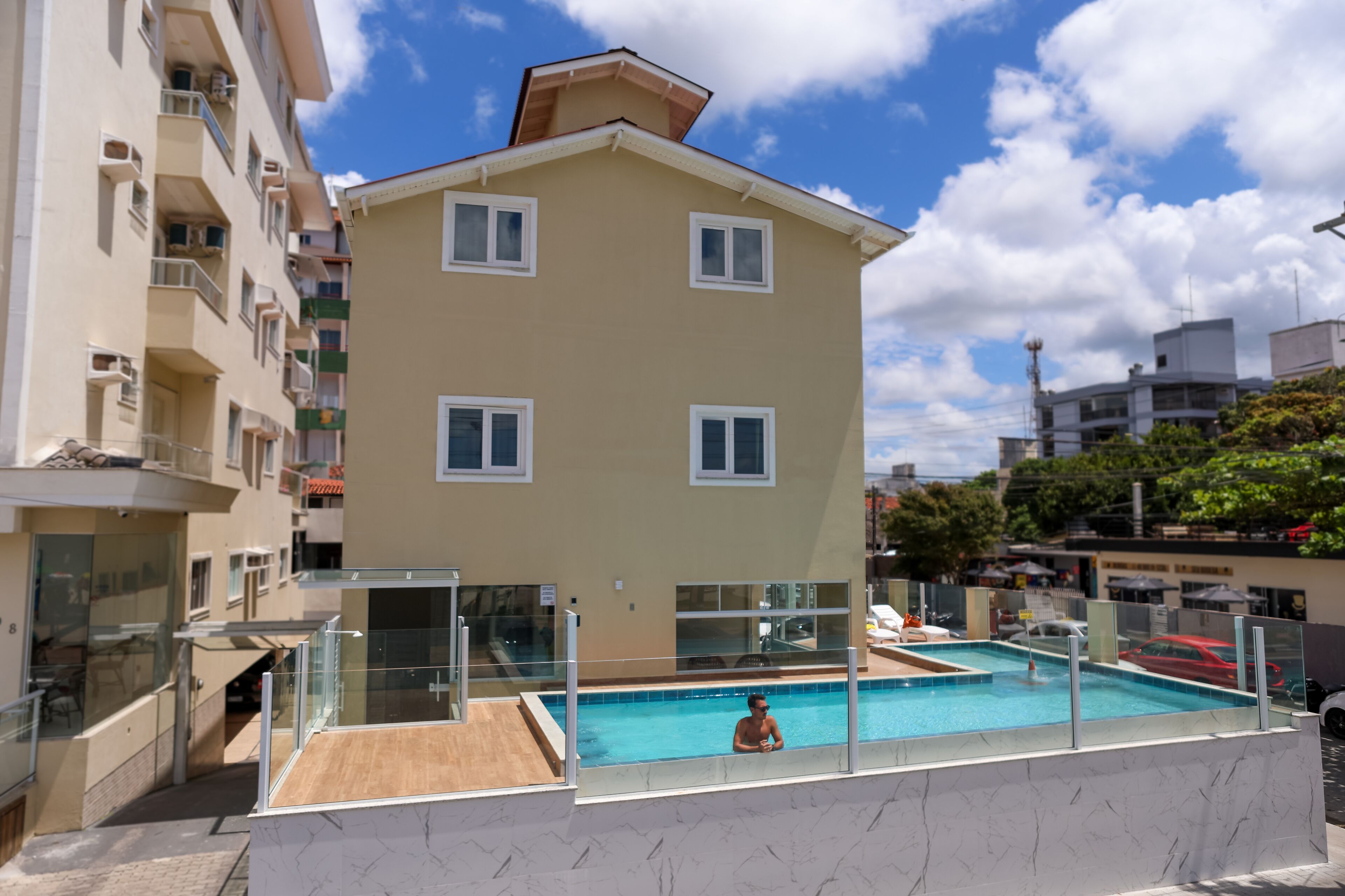 Un edificio residencial con piscina, balcones y cielo despejado.