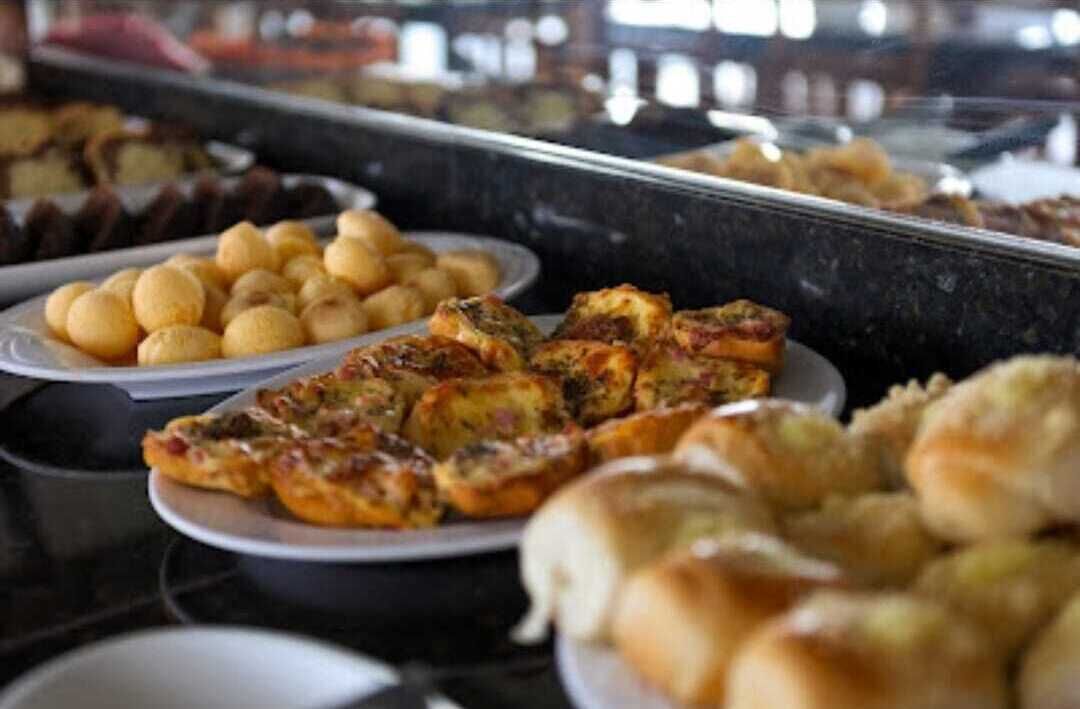 A buffet with various dishes including bread rolls, fried items, and a plate of round pastries.