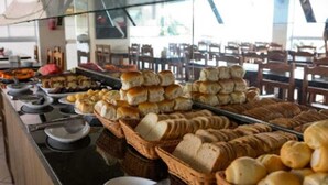 Un bufé con panes y bollería expuestos en cestas.