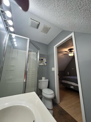 A compact bathroom with a glass shower enclosure, a white toilet, and a bathtub. - Relaxing lake front home with beautiful view on the lake, sleeps 7.  (Creal Springs)