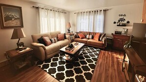 A living room with two sofas, a coffee table, a rug, and a wooden floor. - Home Away from home, fully/equipped, nearJBER, private parking <4 miles Downtown (Anchorage)