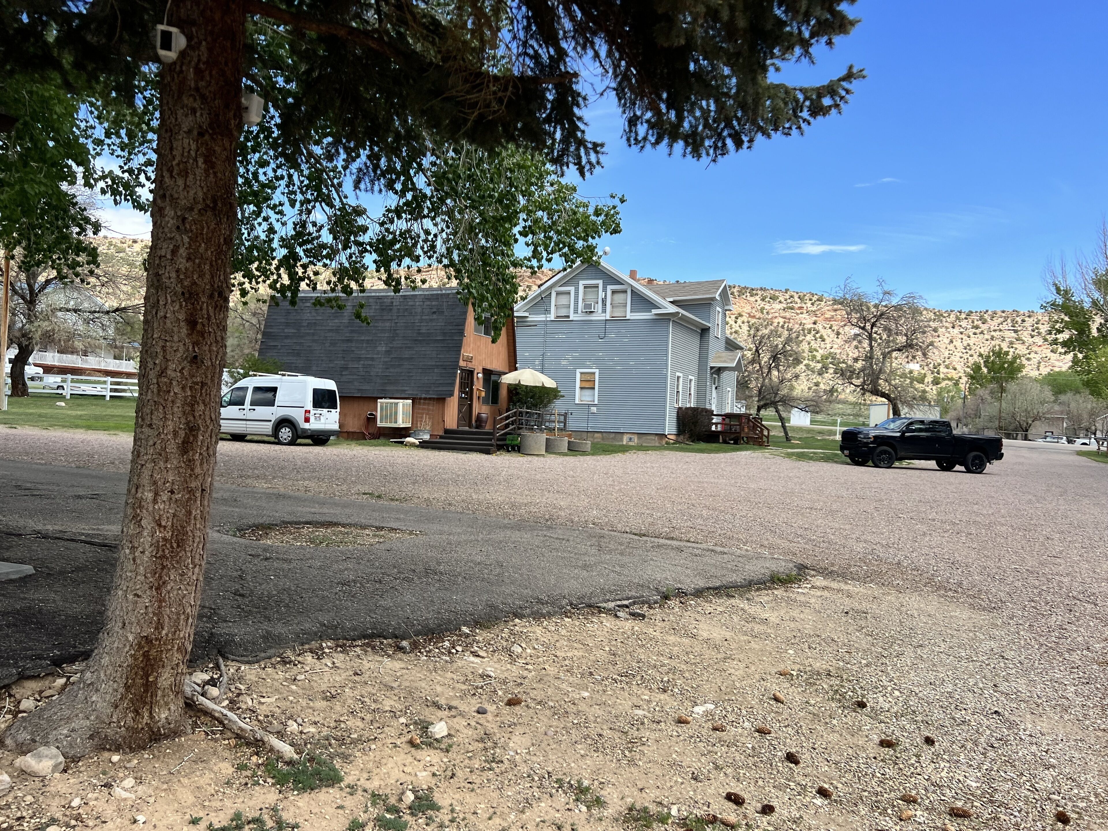 A residential area with houses, a driveway, and a gravel path.