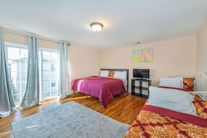 Quarto com cama, televisão e radiador.