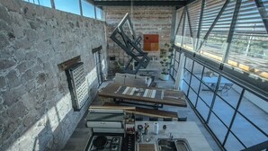 Una cucina con piano cottura a gas, lavello e tavoli di legno.